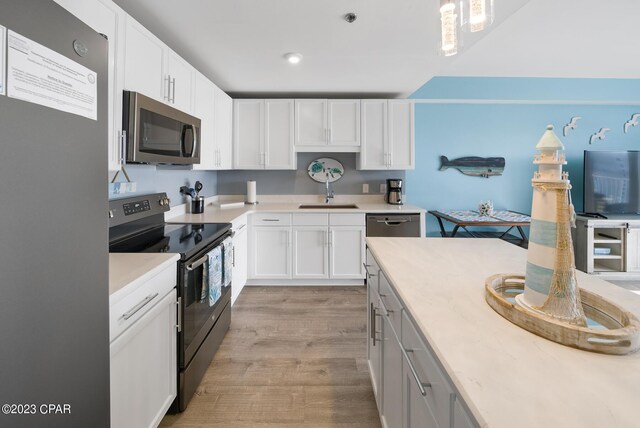 kitchen with white cabinetry, sink, stainless steel appliances, and light wood-type flooring