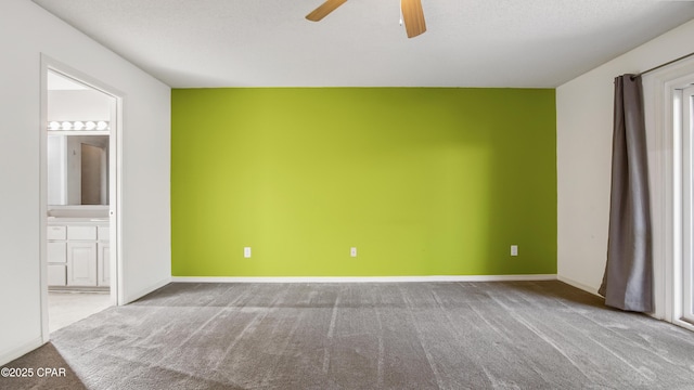 unfurnished room with carpet, ceiling fan, and a textured ceiling