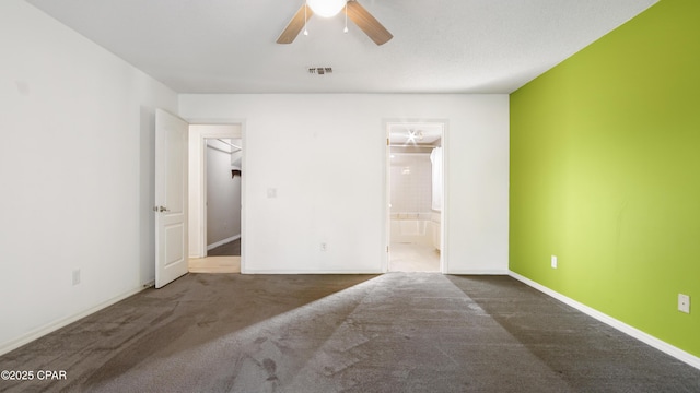 spare room with ceiling fan and dark carpet