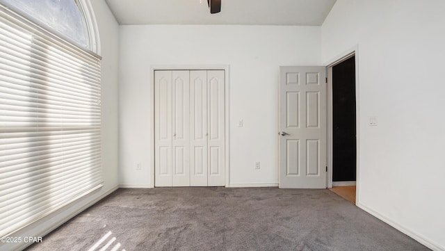 unfurnished bedroom featuring ceiling fan, a closet, and light colored carpet