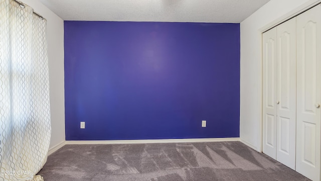 unfurnished bedroom with carpet, a textured ceiling, and a closet