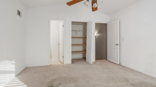 unfurnished bedroom featuring light colored carpet, vaulted ceiling, and ceiling fan