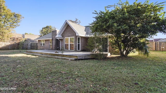 back of house featuring a lawn and a deck