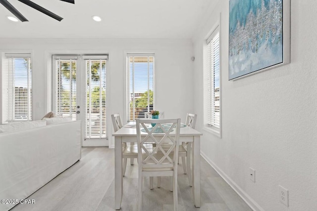 dining area with light hardwood / wood-style flooring and ceiling fan