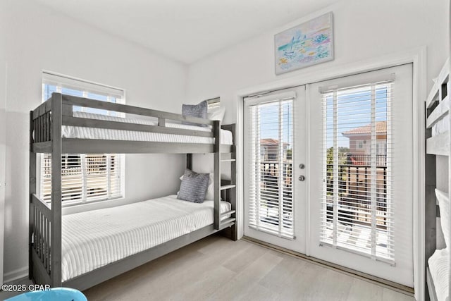 bedroom featuring access to exterior, french doors, and light hardwood / wood-style floors