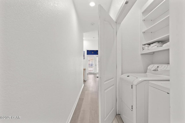 washroom with washer and clothes dryer and light hardwood / wood-style floors