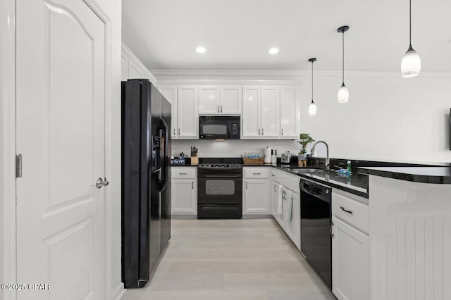 kitchen featuring sink, black appliances, pendant lighting, light hardwood / wood-style floors, and white cabinetry