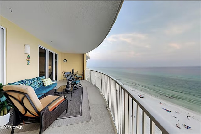 balcony featuring a water view and a view of the beach