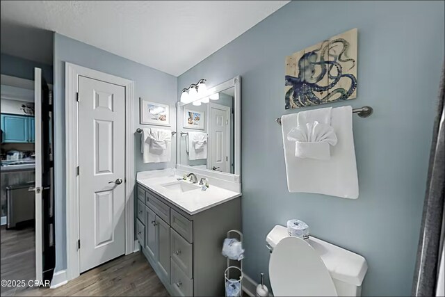 bathroom with vanity, hardwood / wood-style floors, and toilet