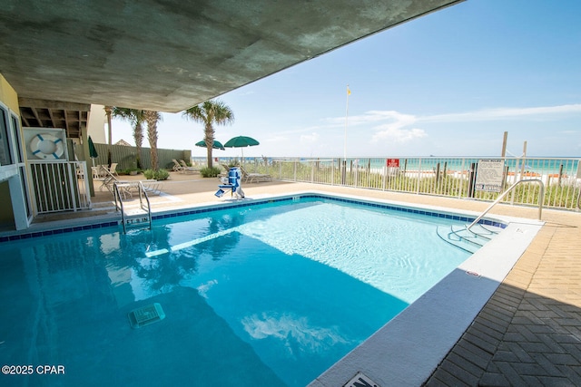 view of swimming pool featuring a water view and a patio area