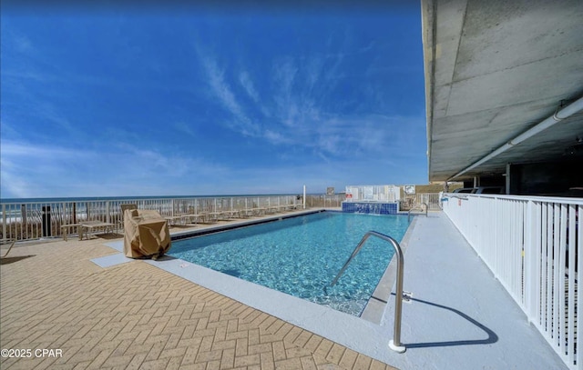 view of swimming pool with pool water feature and a patio