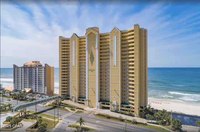 view of building exterior with a water view and a view of the beach