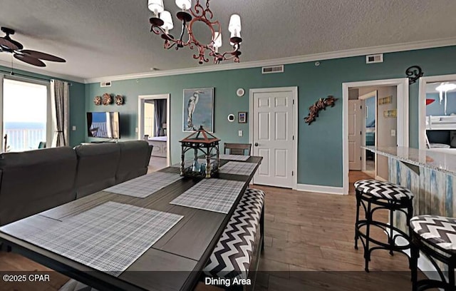 dining room with ornamental molding, dark hardwood / wood-style floors, and a textured ceiling