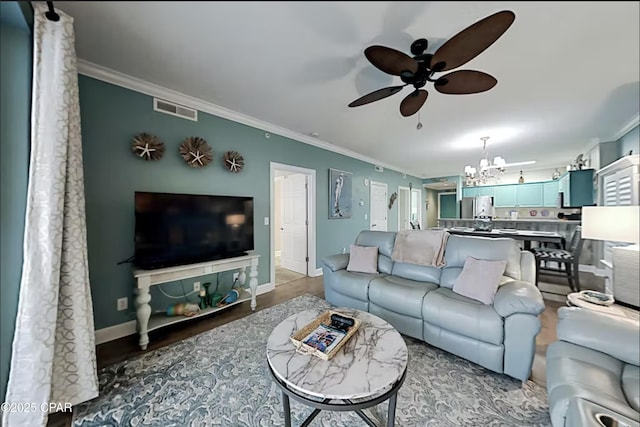 living room featuring ceiling fan with notable chandelier, ornamental molding, and hardwood / wood-style floors