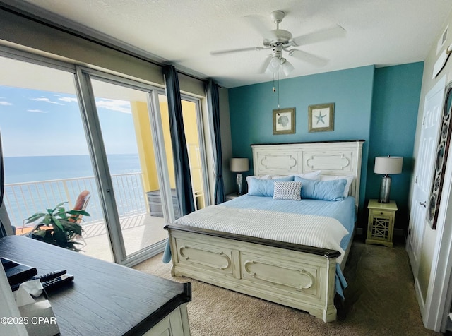 bedroom with a water view, ceiling fan, access to exterior, and a textured ceiling