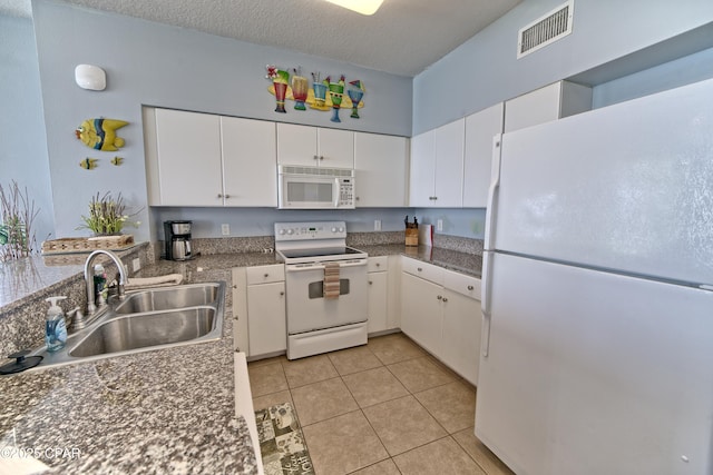 kitchen featuring white cabinetry, a sink, white appliances, and visible vents