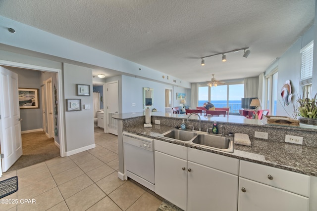 kitchen featuring white cabinetry, a ceiling fan, light tile patterned flooring, dishwasher, and a sink