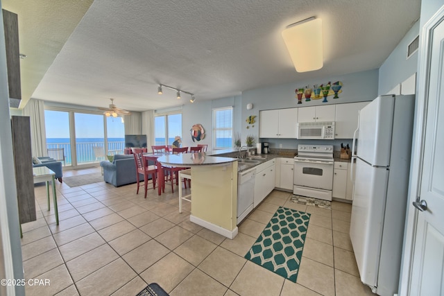 kitchen with white cabinetry, ceiling fan, kitchen peninsula, a textured ceiling, and white appliances