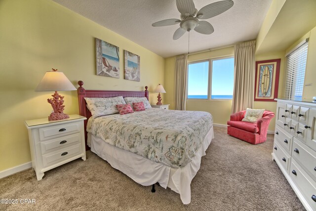 bedroom featuring a textured ceiling, ceiling fan, and light carpet