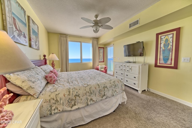 carpeted bedroom featuring a textured ceiling and ceiling fan