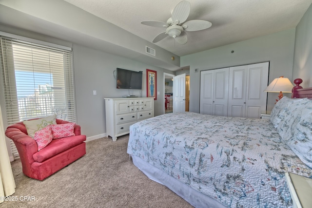 bedroom with a closet, baseboards, a ceiling fan, carpet floors, and visible vents