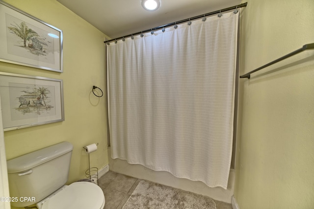 bathroom with tile patterned flooring, shower / bathtub combination with curtain, and toilet