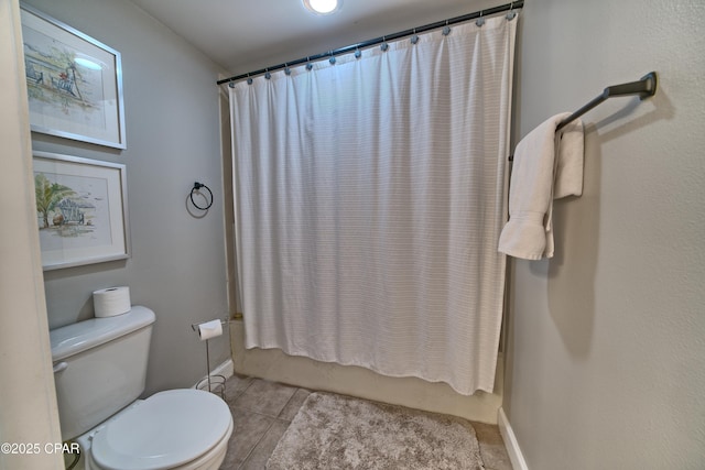 full bath with tile patterned floors, shower / tub combo with curtain, baseboards, and toilet