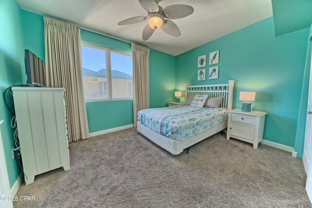 bedroom with a textured ceiling, light colored carpet, and ceiling fan