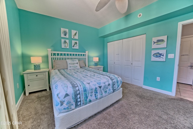 carpeted bedroom with ceiling fan, a closet, and a textured ceiling