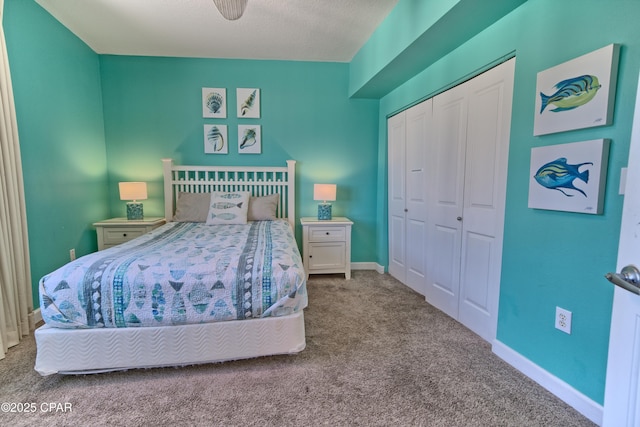 bedroom with a textured ceiling, carpet floors, a closet, and ceiling fan