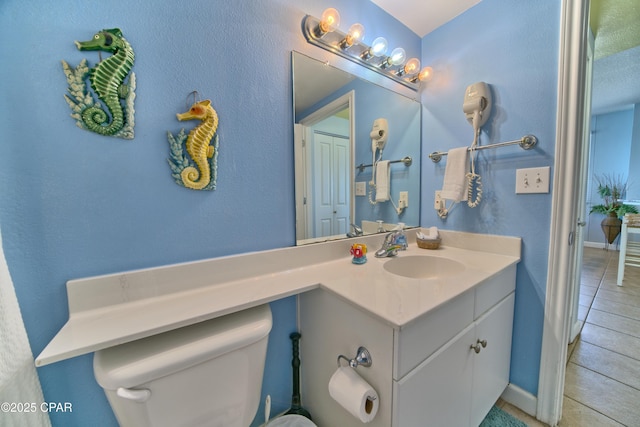 bathroom with tile patterned floors, vanity, and toilet