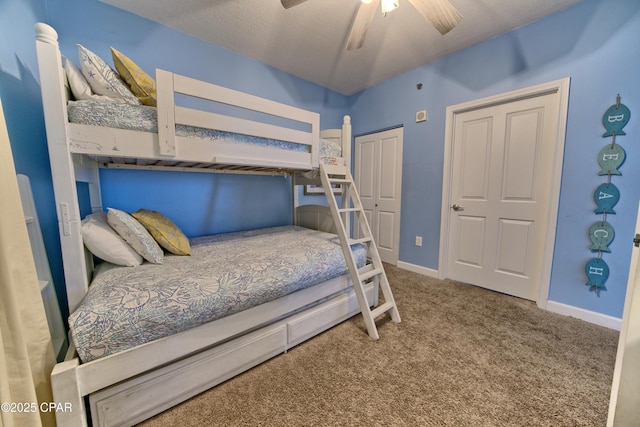 carpeted bedroom featuring ceiling fan, a closet, and a textured ceiling