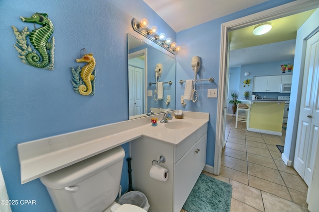 bathroom with toilet, tile patterned floors, and vanity