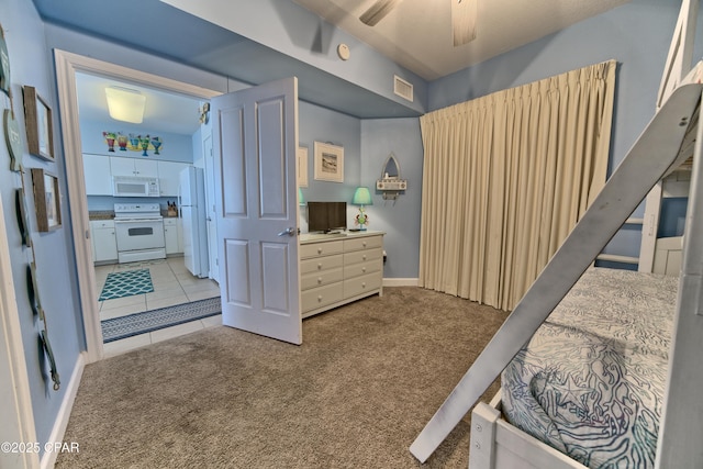 carpeted bedroom with ceiling fan and white refrigerator