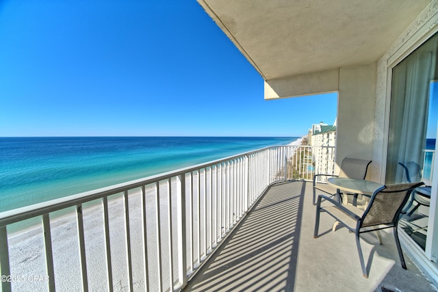 balcony with a water view and a beach view