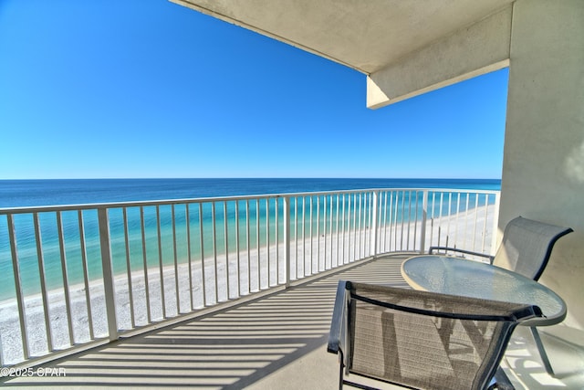 balcony featuring a view of the beach and a water view