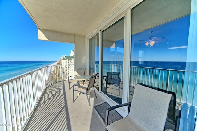 balcony featuring a view of the beach and a water view