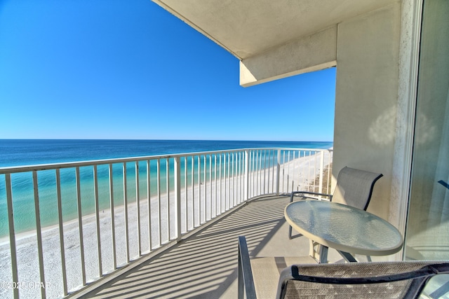 balcony with a water view and a view of the beach