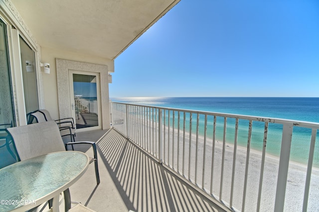 balcony featuring a water view and a beach view