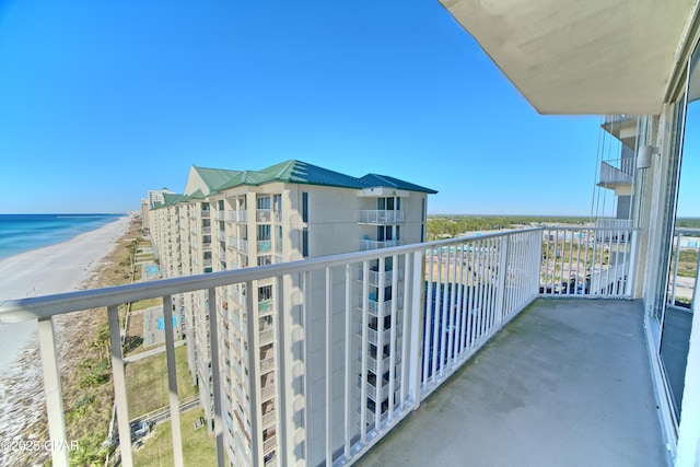 balcony featuring a water view and a beach view