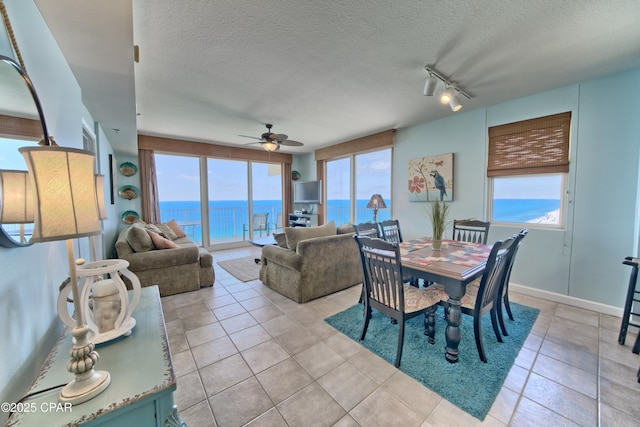 dining area featuring ceiling fan, plenty of natural light, and a textured ceiling