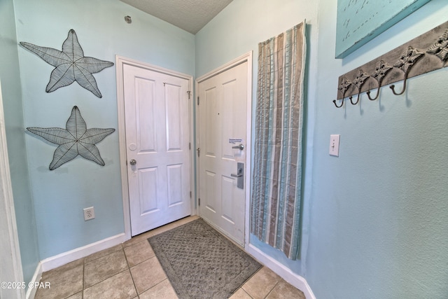 entryway featuring light tile patterned floors and baseboards