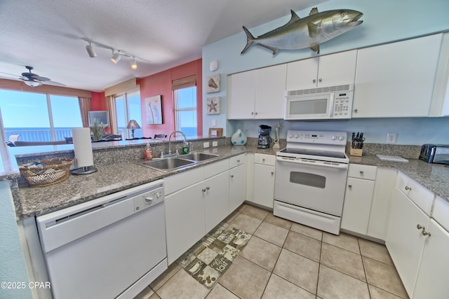 kitchen featuring white cabinetry, sink, light tile patterned floors, and white appliances