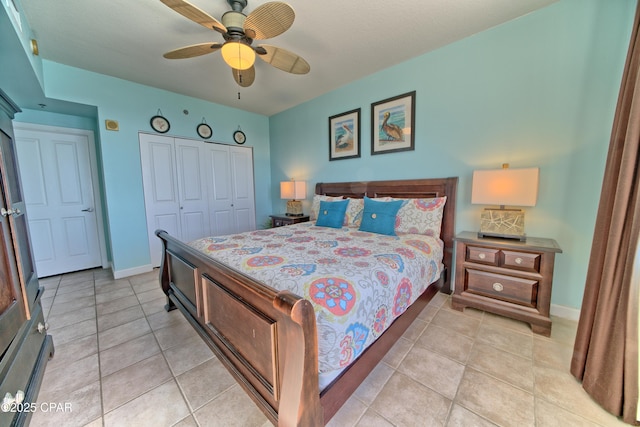 bedroom with a closet, light tile patterned floors, baseboards, and a ceiling fan