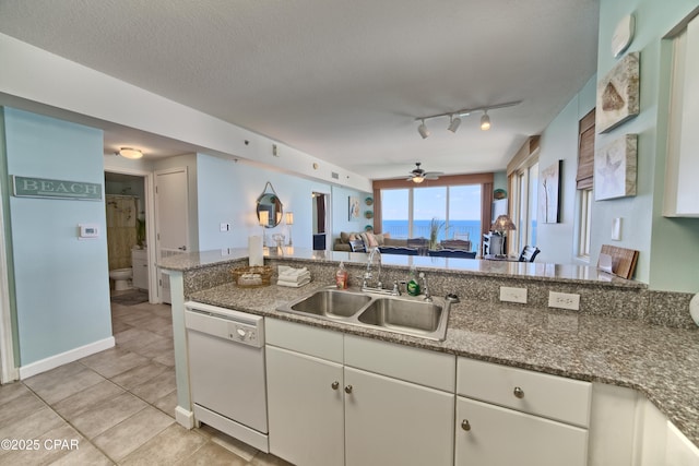 kitchen with ceiling fan, light tile patterned floors, a sink, white dishwasher, and open floor plan