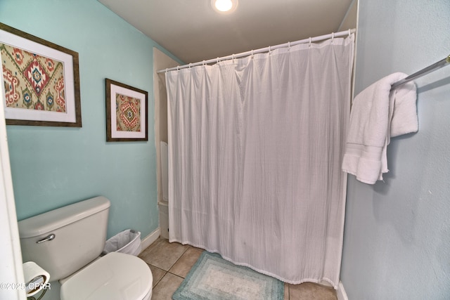 bathroom featuring tile patterned floors, curtained shower, baseboards, and toilet