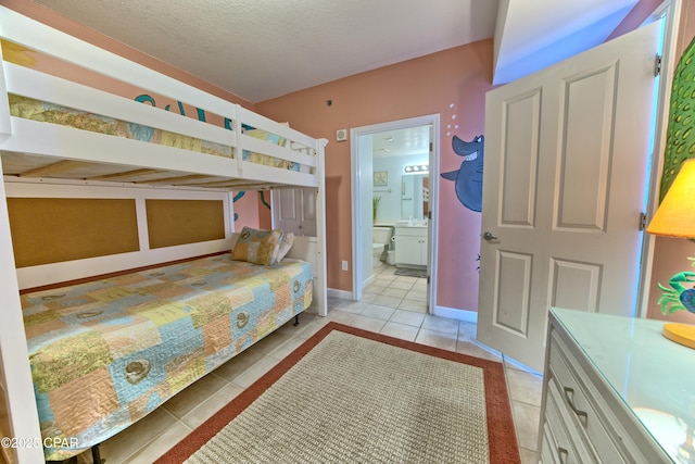 bedroom featuring tile patterned flooring, baseboards, and connected bathroom