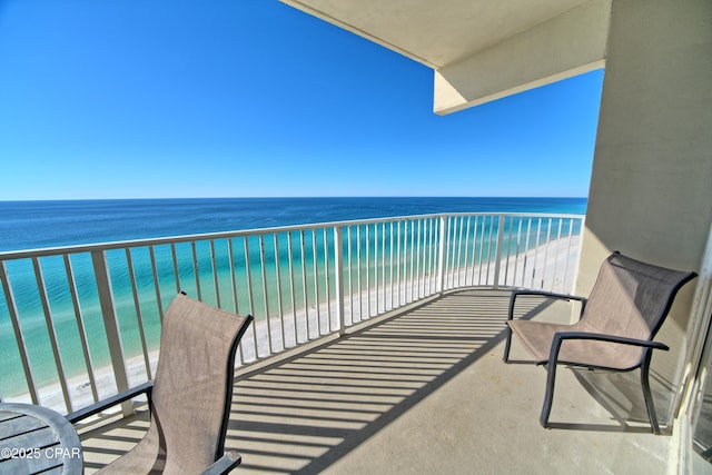 balcony featuring a beach view and a water view