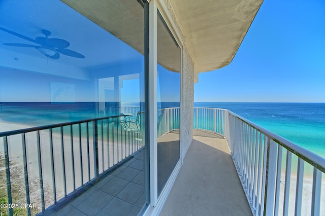 balcony featuring ceiling fan and a water view