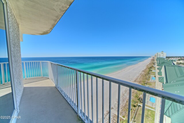 balcony featuring a view of the beach and a water view